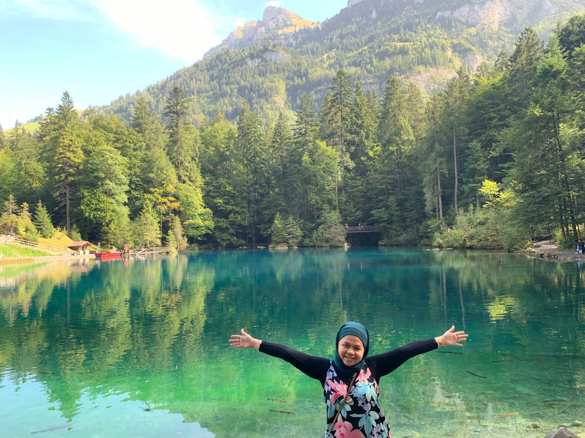 Pelancong membuka tangan di tepi tasik alp Switzerland yang biru kehijauan