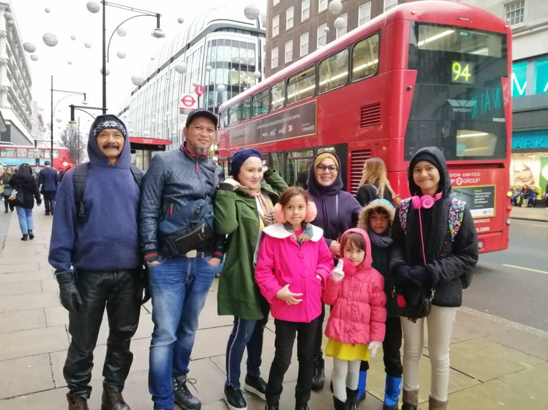 Pelanggan di sebelah bas dua tingkat merah di London